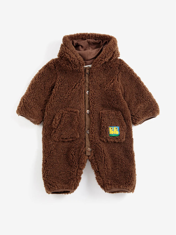 A brown sherpa fleece hooded snowsuit for toddlers, featuring a button-up front, two front patch pockets, and a small cartoon patch on the pocket, shown against a plain light background.