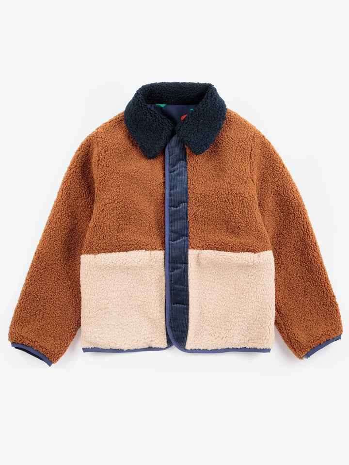 A children's sherpa fleece jacket with a colorblock design, featuring a warm brown upper body, a beige lower panel, and a navy blue collar, placket, and cuffs.