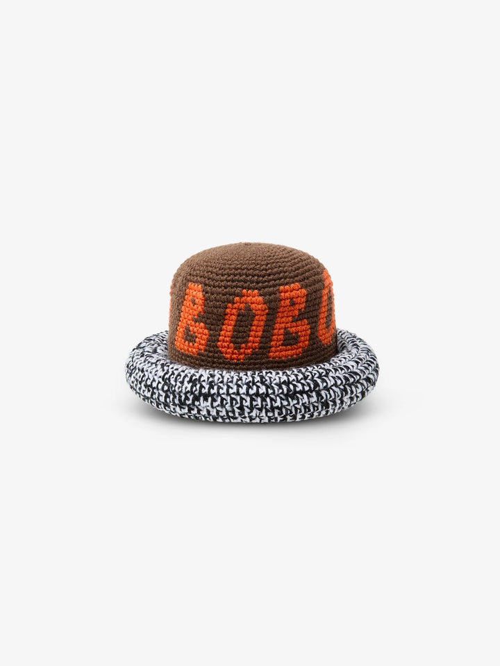 Brown crochet bucket hat with orange logo lettering and black and white houndstooth brim